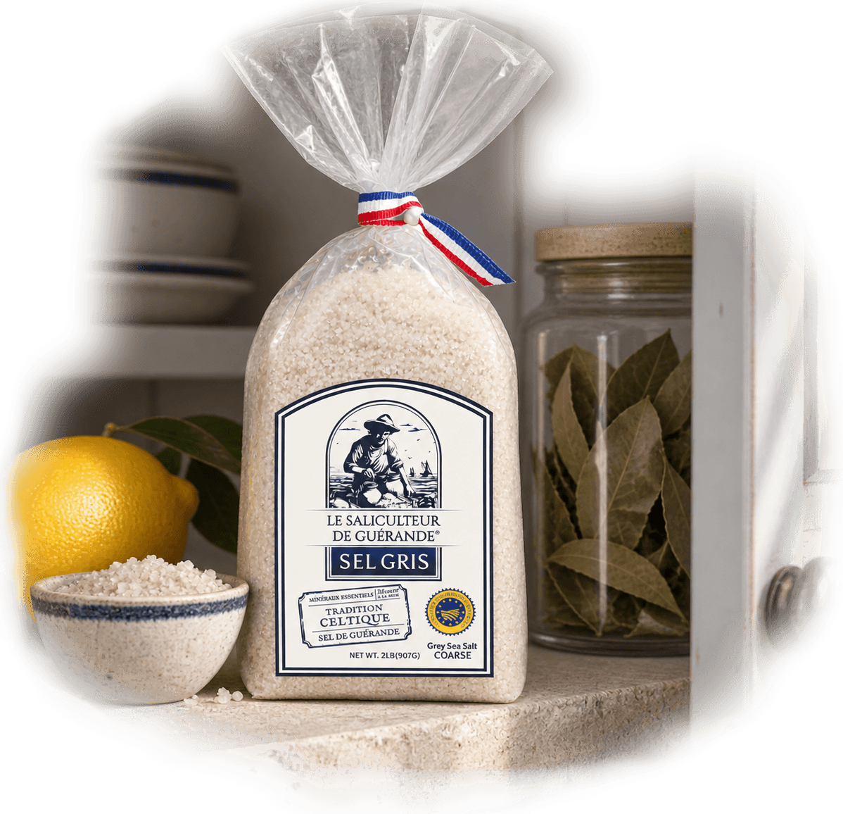 The Celtic Salt Coarse 907g bag on a kitchen shelf with a lemon, bay leaves and a bowl of salt