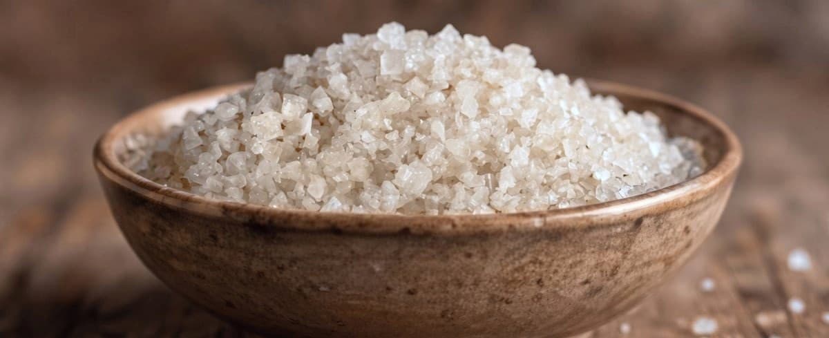 A wooden bowl of coarse grey salt