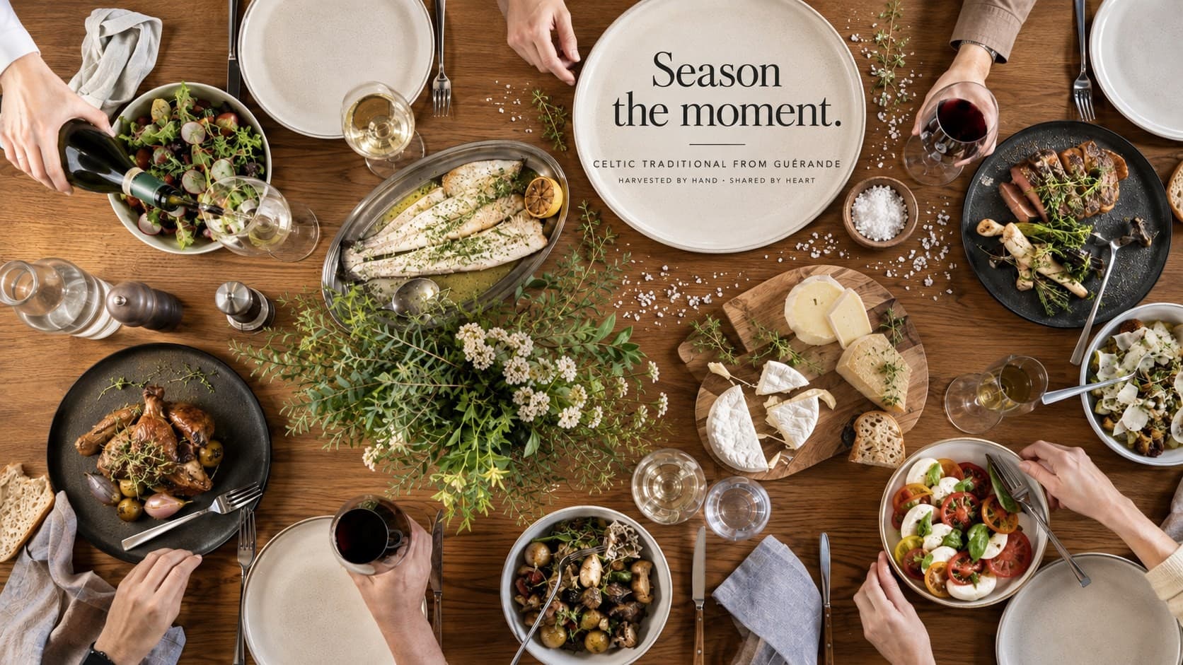Season the moment. Celtic traditional from Guérande, harvested by hand, shared by heart. A table laid with fish, salads, cheese and wine.